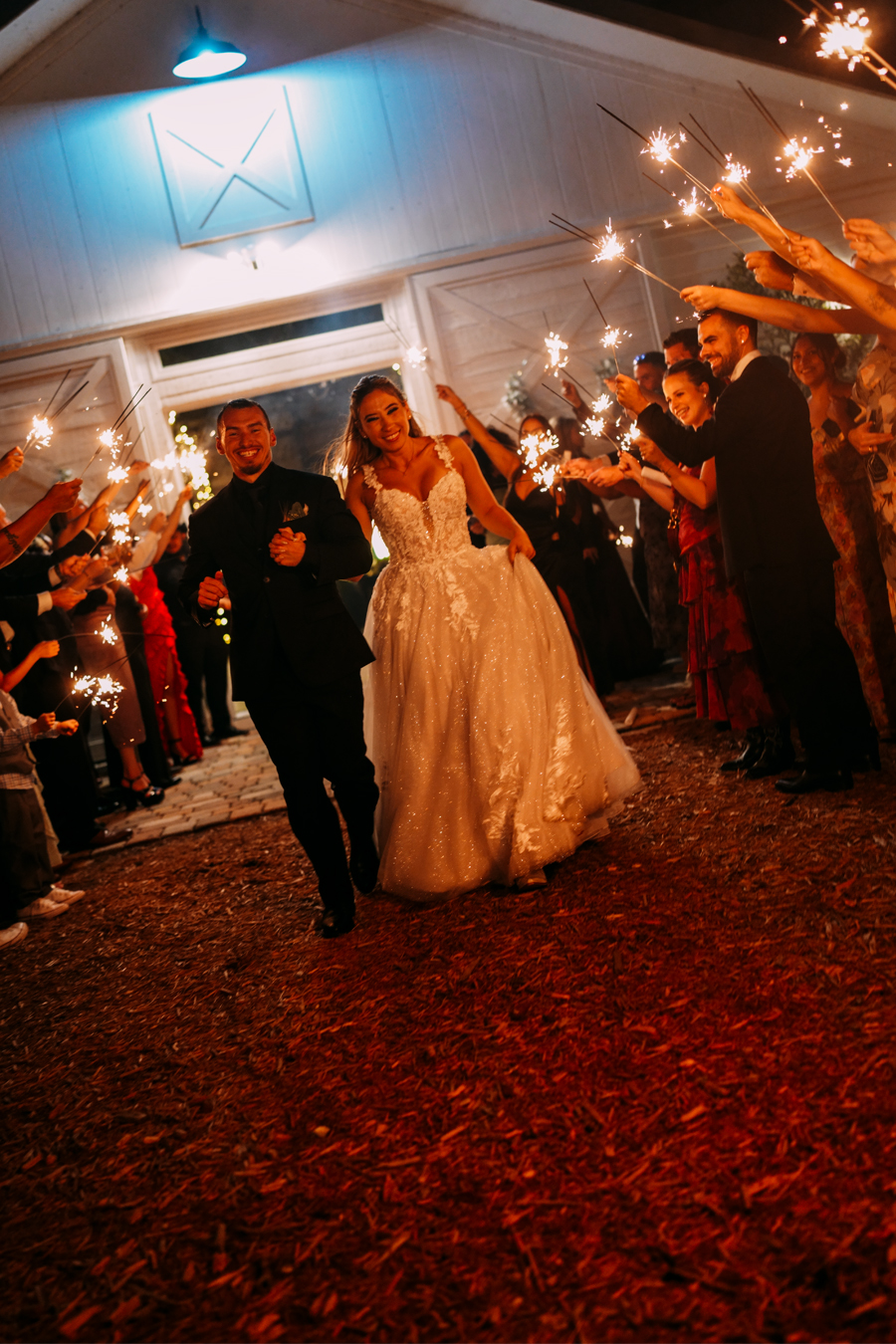 Bride and groom walking out of the reception with sparklers at Ever After Farms Ranch